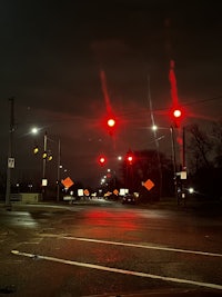a red traffic light on a street at night